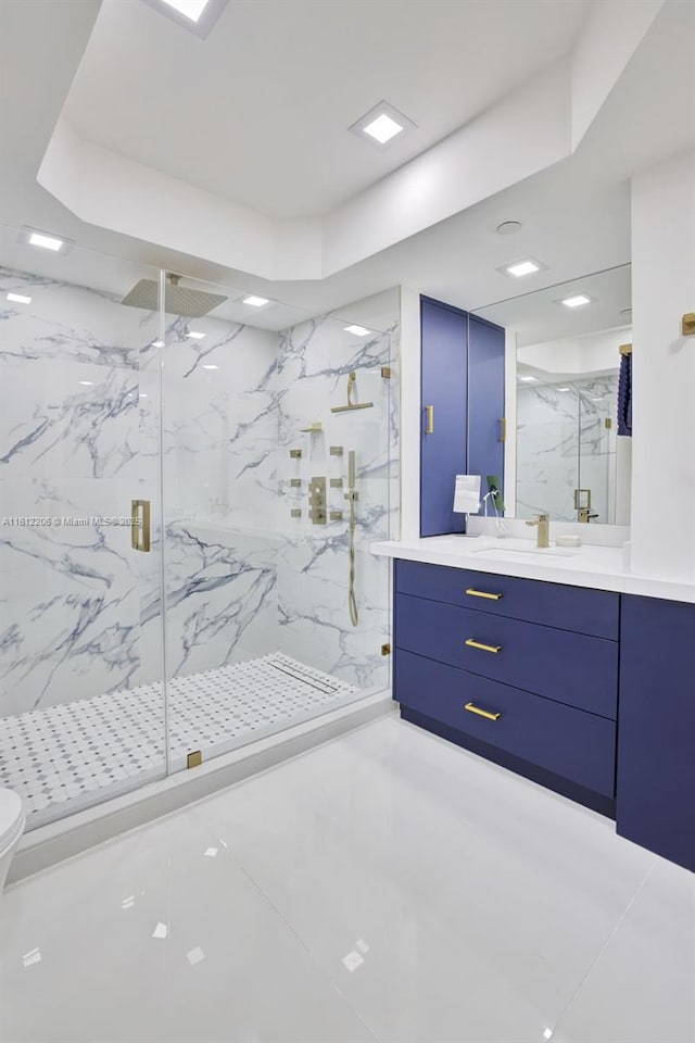 full bathroom featuring toilet, a raised ceiling, a marble finish shower, and vanity