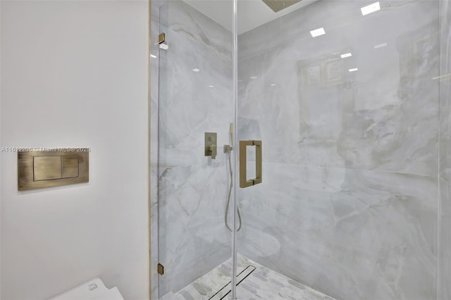 full bath featuring toilet and a marble finish shower