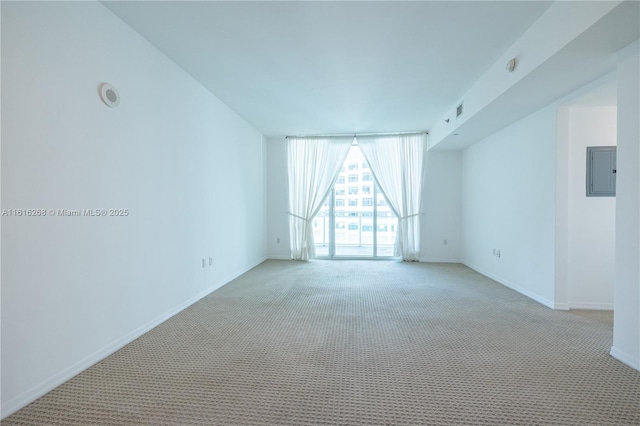 unfurnished room featuring electric panel, light carpet, and floor to ceiling windows