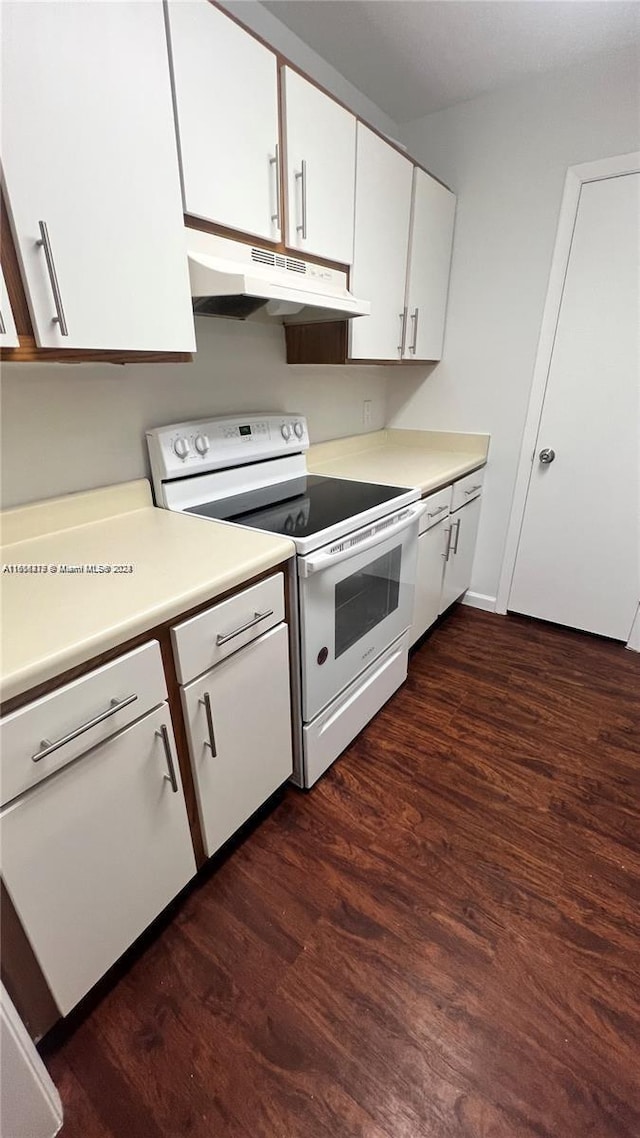 kitchen featuring white cabinetry, dark hardwood / wood-style flooring, and white electric range