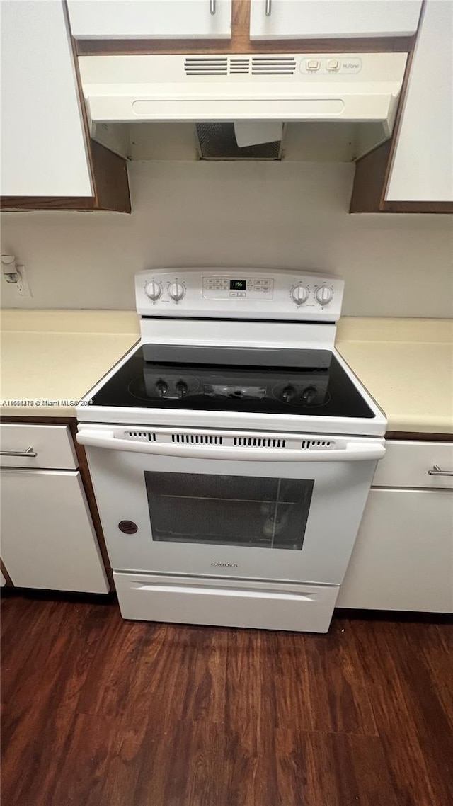 kitchen with white cabinets, electric range, extractor fan, and dark wood-type flooring