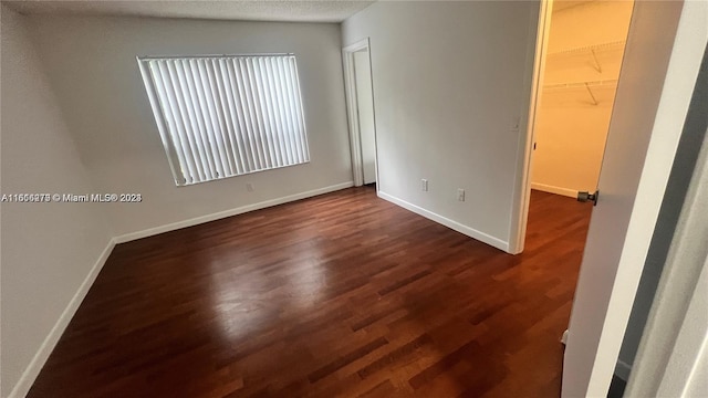 unfurnished room featuring dark hardwood / wood-style flooring and a textured ceiling