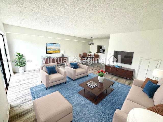 living room with a textured ceiling, a notable chandelier, and wood-type flooring