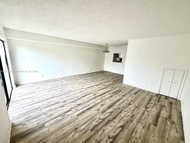 spare room featuring a textured ceiling and wood-type flooring