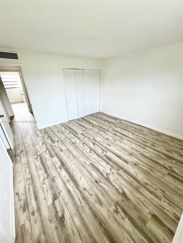 unfurnished bedroom featuring light hardwood / wood-style floors and a closet