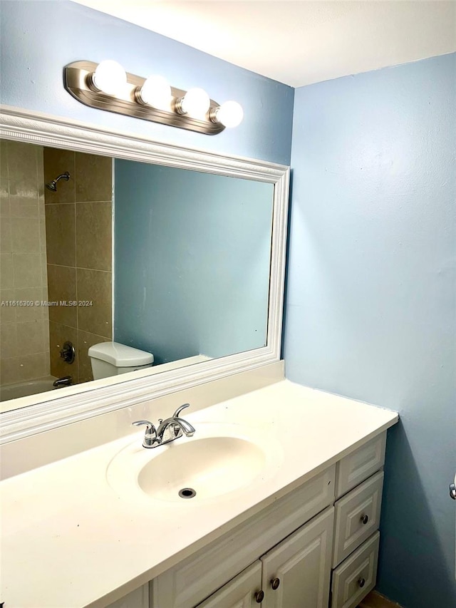 full bathroom featuring vanity, toilet, and tiled shower / bath combo