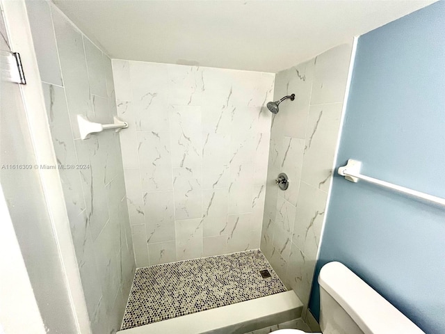 bathroom with tiled shower and toilet