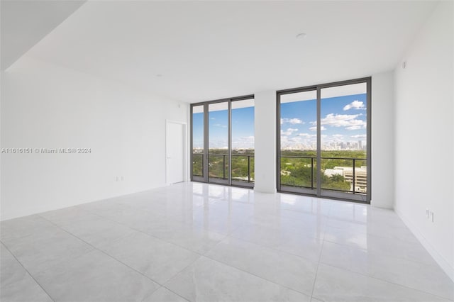 tiled spare room with floor to ceiling windows