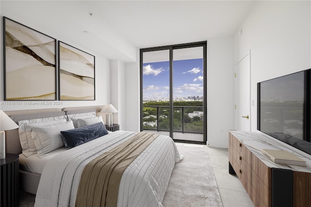 bedroom with access to exterior, a wall of windows, and light tile patterned flooring