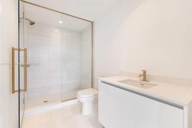 bathroom featuring tile patterned flooring, vanity, toilet, and a shower with shower door