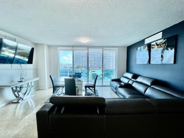 living room with a textured ceiling and a wall of windows