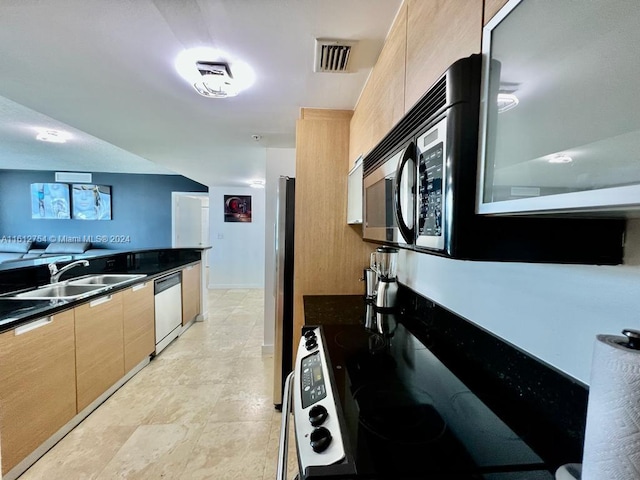 kitchen with stainless steel dishwasher, light brown cabinets, and sink