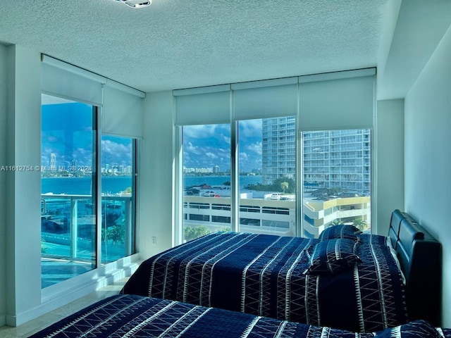 bedroom featuring a textured ceiling and a water view