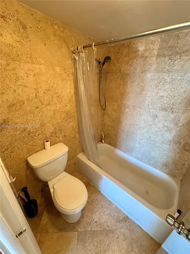 bathroom featuring shower / tub combo and toilet