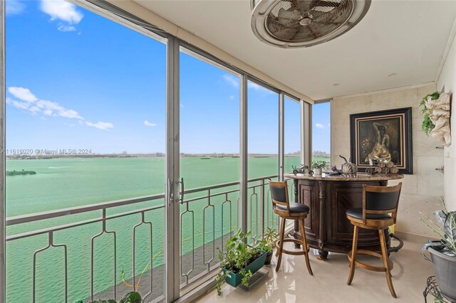 sunroom featuring a water view