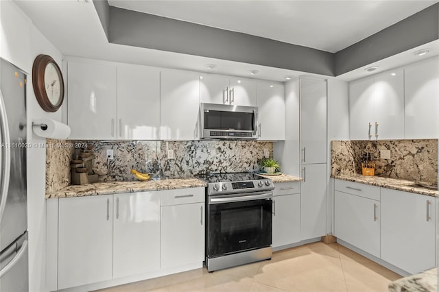 kitchen with light tile patterned flooring, white cabinetry, tasteful backsplash, and stainless steel appliances