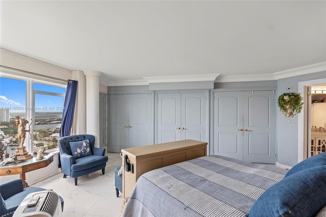 bedroom with ornamental molding and two closets