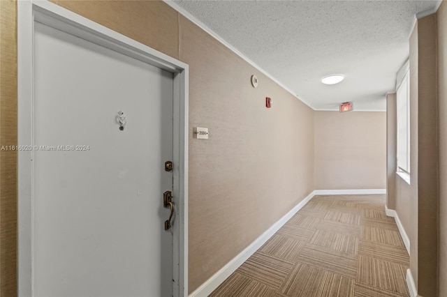 hall featuring a textured ceiling