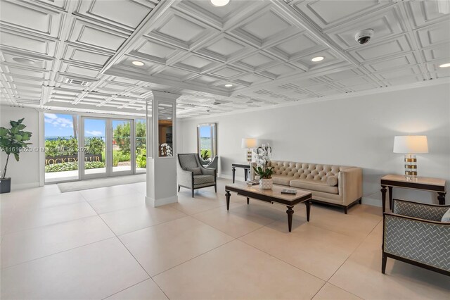 tiled living room with decorative columns and french doors