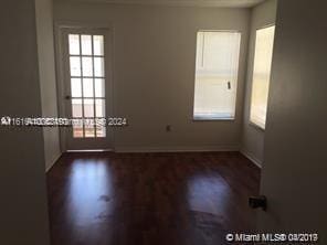 unfurnished room with a healthy amount of sunlight and dark hardwood / wood-style flooring