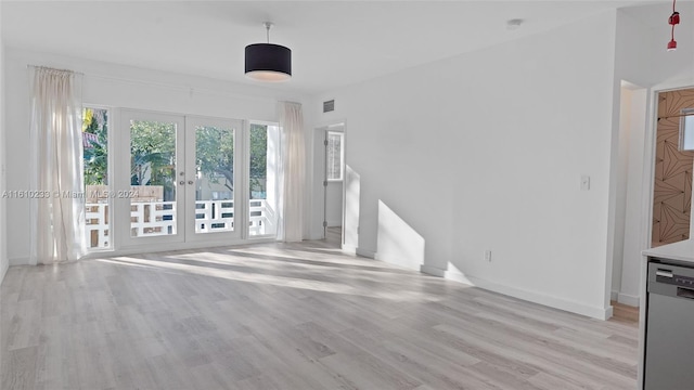 unfurnished living room featuring french doors and light wood-type flooring