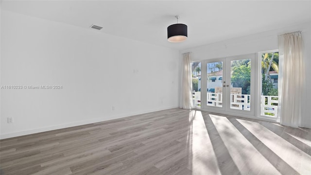 spare room featuring light wood-type flooring and french doors