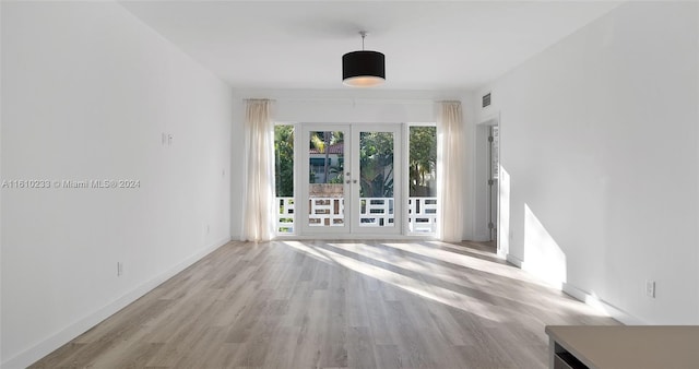 unfurnished living room featuring french doors and light wood-type flooring