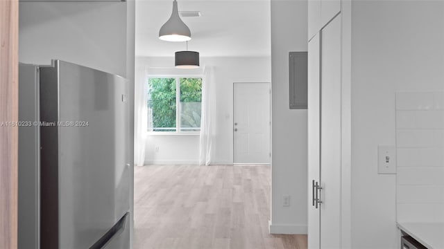 hallway with electric panel and light hardwood / wood-style flooring