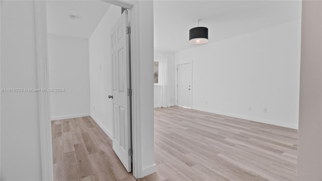 corridor with light hardwood / wood-style floors