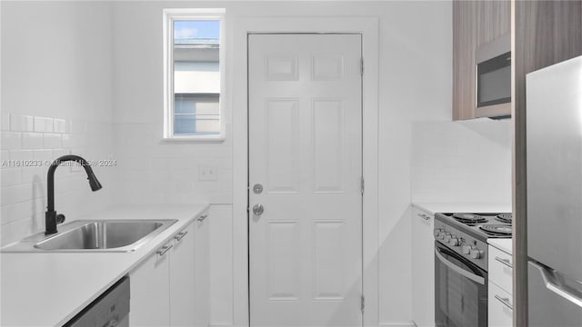 kitchen with white cabinetry, appliances with stainless steel finishes, sink, and a healthy amount of sunlight