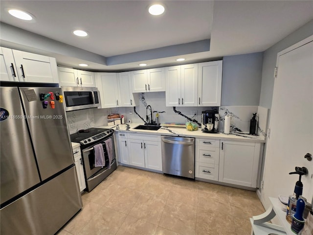 kitchen with sink, light tile patterned floors, white cabinetry, stainless steel appliances, and decorative backsplash