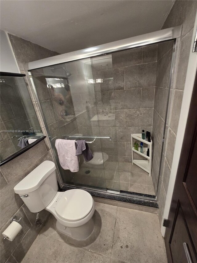 bathroom with toilet and a shower with door