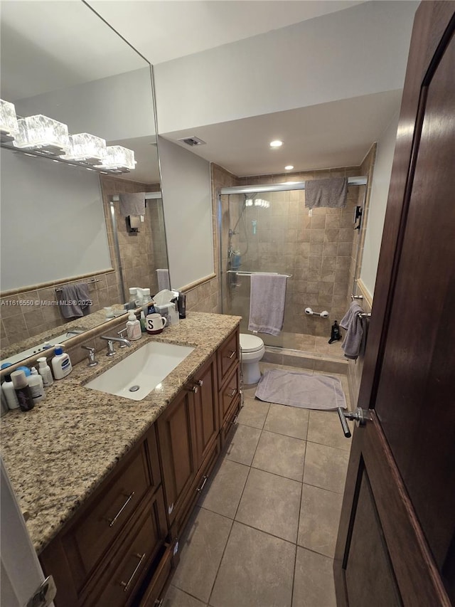 bathroom featuring vanity, walk in shower, tile patterned floors, and toilet