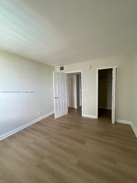 unfurnished bedroom with a closet and wood-type flooring