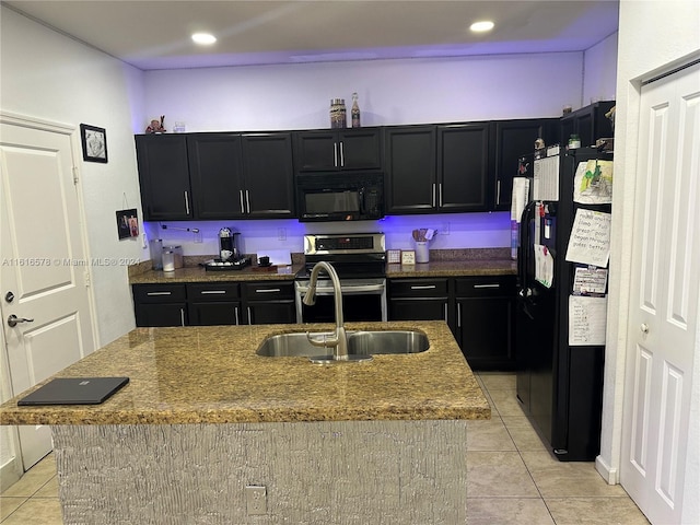 kitchen featuring light tile patterned floors, sink, a kitchen island with sink, and black appliances