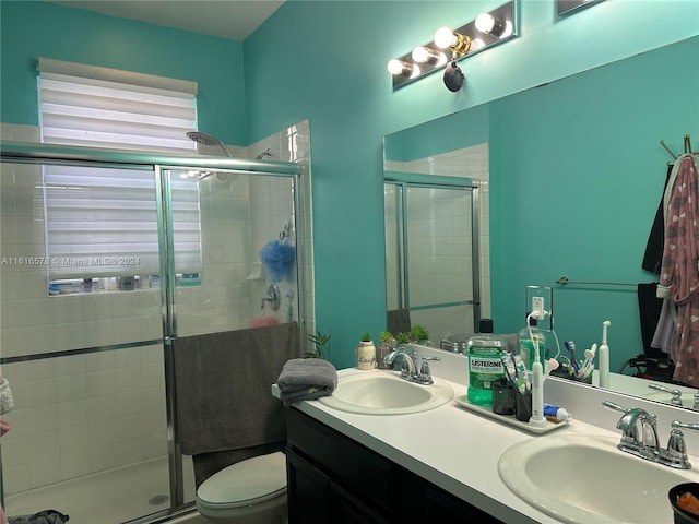 bathroom featuring vanity, toilet, and a shower with shower door