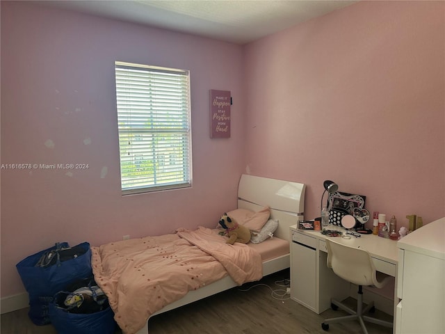 bedroom with dark wood-type flooring and multiple windows