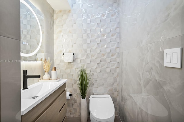 bathroom featuring vanity, toilet, and tile walls