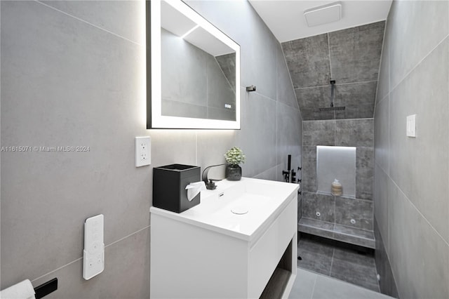 bathroom featuring vanity, a shower, tile walls, and tile patterned flooring