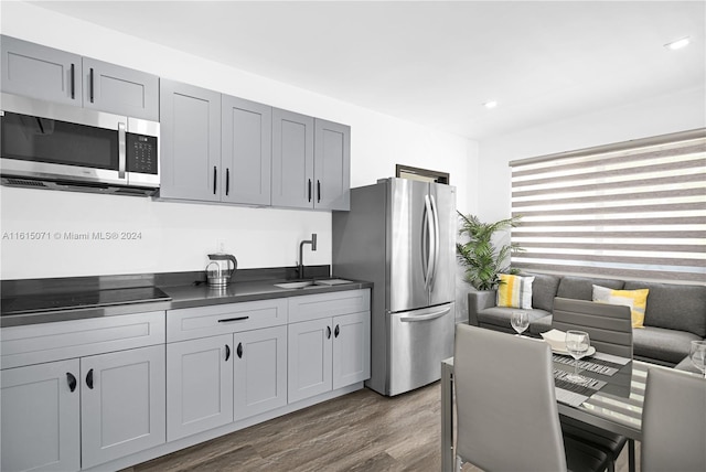 kitchen featuring gray cabinetry, sink, hardwood / wood-style flooring, and stainless steel appliances