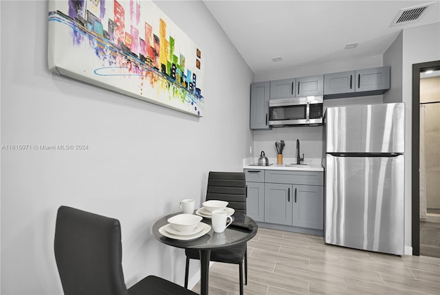 kitchen featuring gray cabinets, appliances with stainless steel finishes, and sink