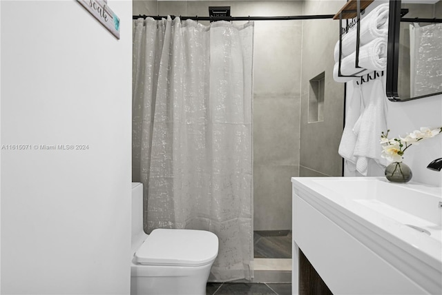 bathroom featuring walk in shower, toilet, vanity, and tile patterned floors