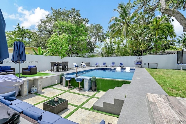 view of swimming pool featuring an outdoor living space, a yard, and a patio area