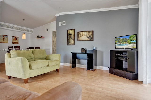 living area featuring visible vents, light wood finished floors, baseboards, vaulted ceiling, and crown molding