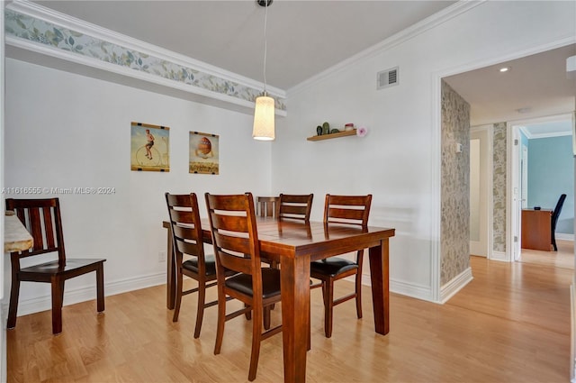 dining area featuring light wood-style flooring, baseboards, visible vents, and ornamental molding