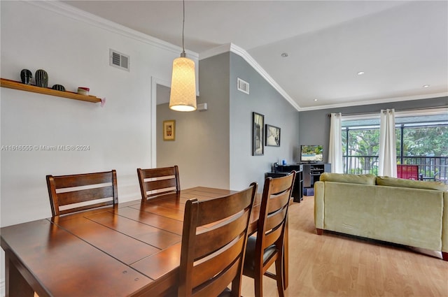 dining space featuring ornamental molding, lofted ceiling, and hardwood / wood-style floors