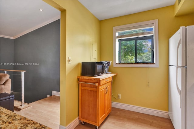 kitchen featuring light wood-style floors, baseboards, freestanding refrigerator, and black microwave