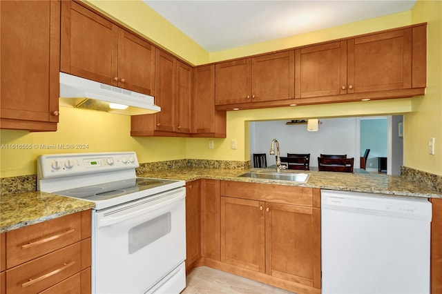 kitchen with sink, light stone countertops, light wood-type flooring, and white appliances