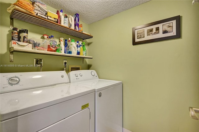 laundry area with a textured ceiling and separate washer and dryer