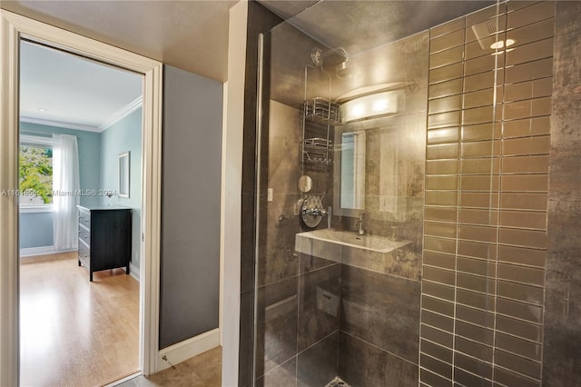 bathroom featuring ornamental molding, vanity, a tile shower, and hardwood / wood-style floors